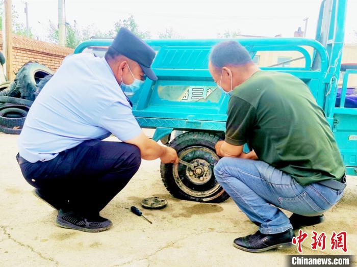 賽旦與民警共同維修三輪摩托車?！∫懒窘?攝